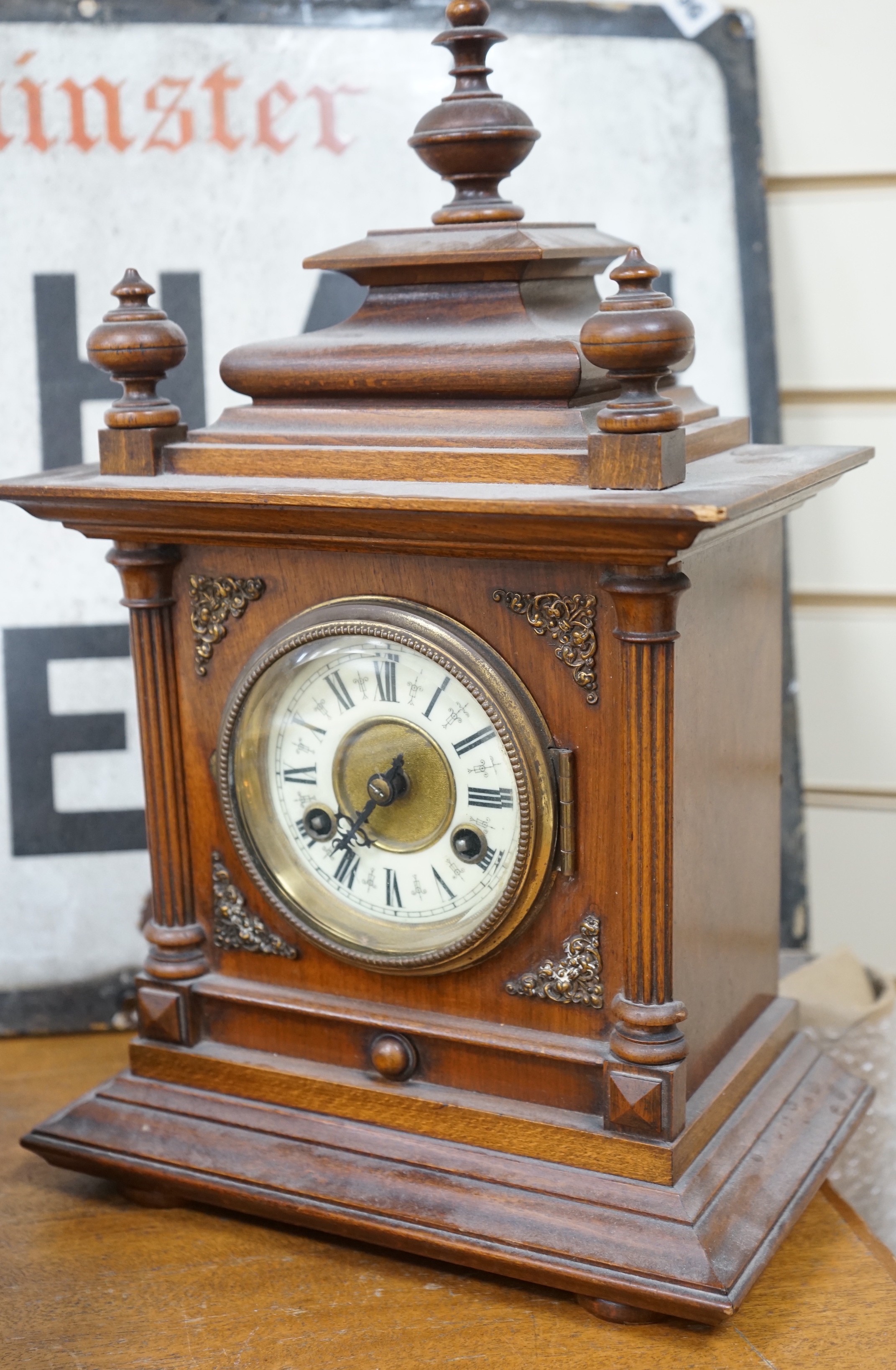 A 19th century German walnut mantel clock with key and pendulum, 40cm tall
